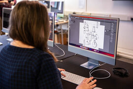 Person working on Illustrator on a Mac computer