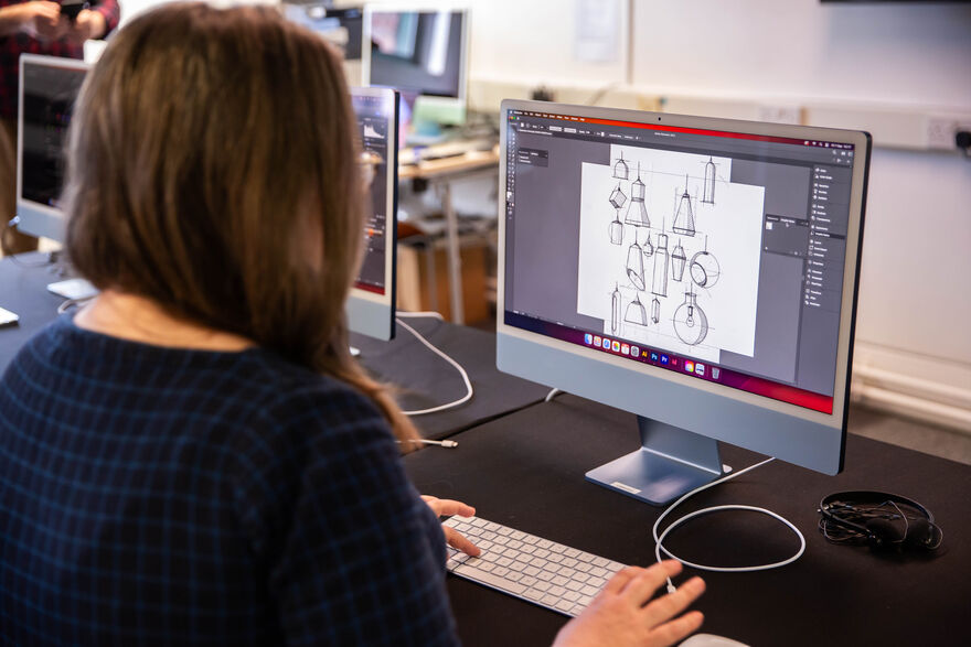 Person working on Illustrator on a Mac computer