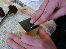 Person carving into a wood block