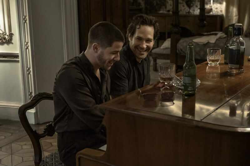 Two men laugh and play piano