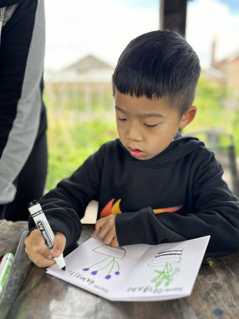 Child drawing flowers in a booklet
