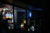Window to DCA's projection booth, showing film canisters and a projector in action
