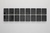 A photograph of an artwork displayed as.a grid of black rectangles. 