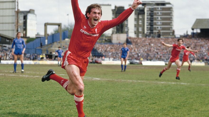 Kenny Dalglish celebrates after scoring a goal. He is wearing a red football strip