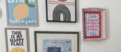 Painted tray displayed on wall beside framed prints