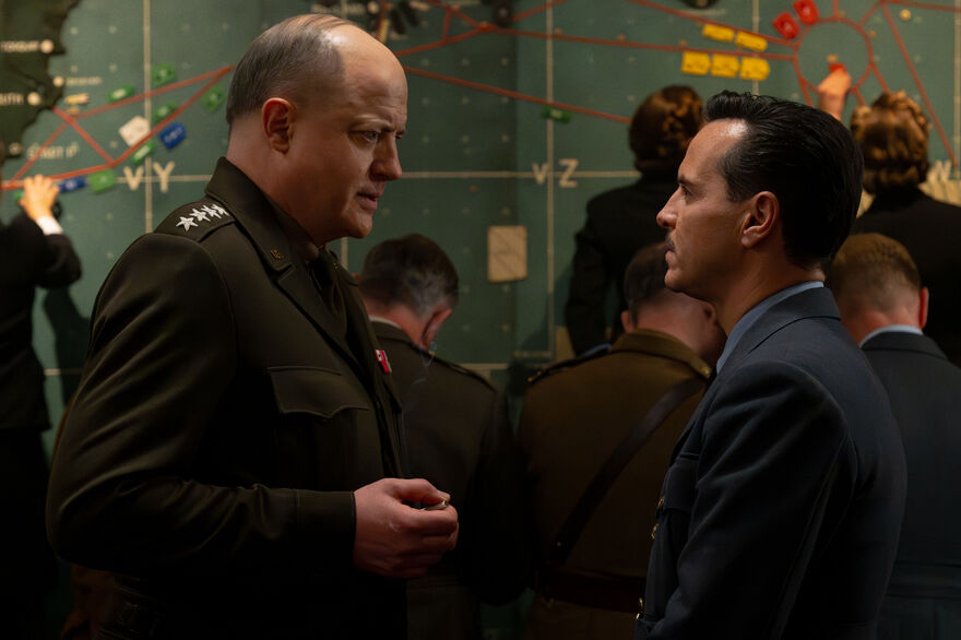 A general talks to a man in uniform in a war room