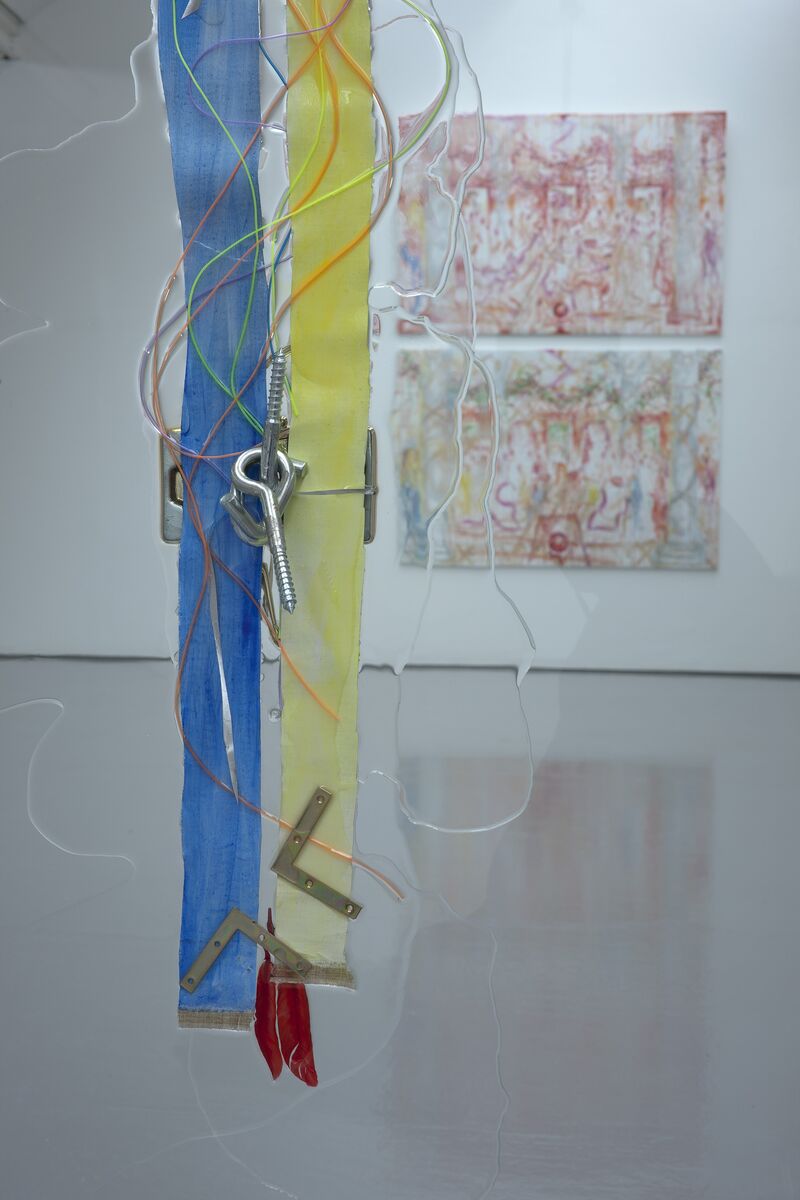 From Jutta Koether's exhibition. Two strips of yellow and blue fabric, keys, nuts, bolts and wires are encased in clear liquid acrylic. 