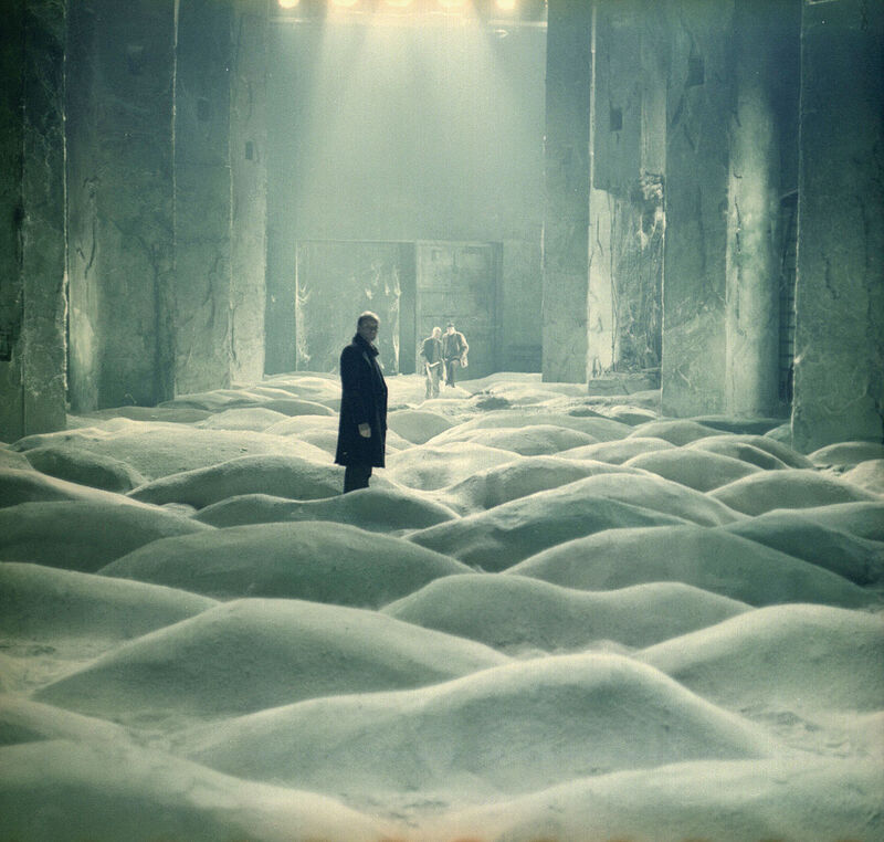 Three men in a strange undulating room