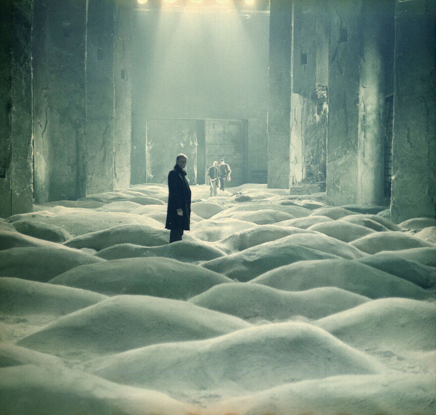 Three men in a strange undulating room
