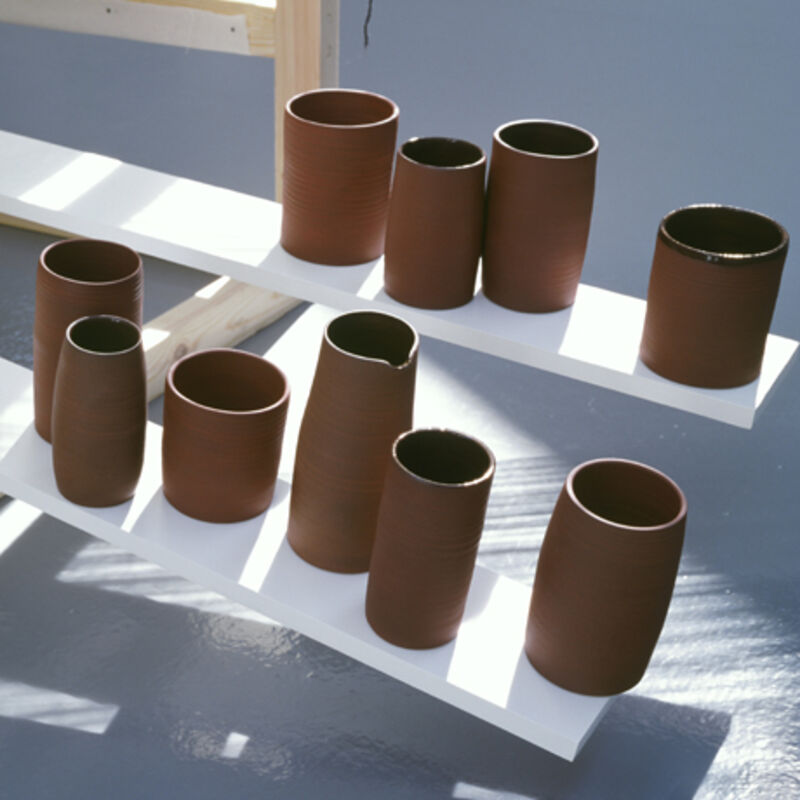 From Claire Barclay's exhibition at DCA. Terracotta pots sit on a white bench.