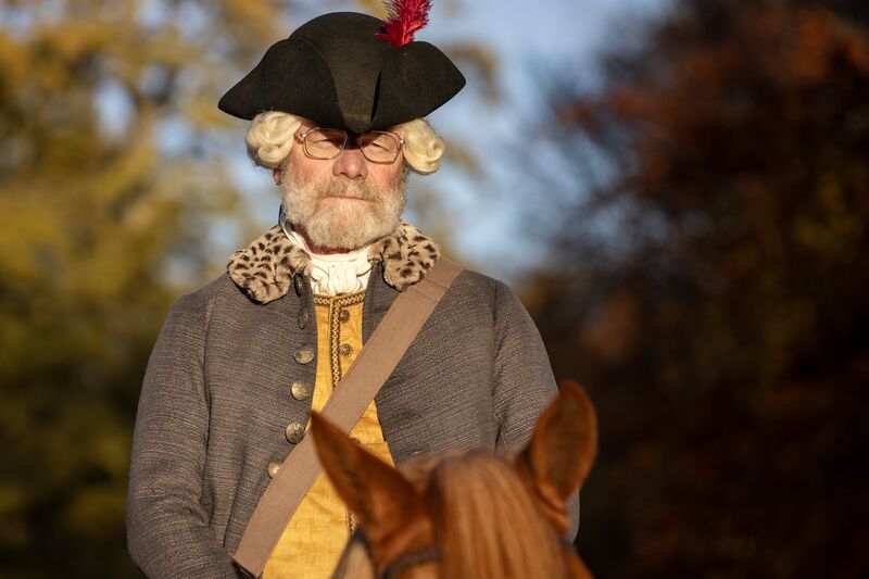 A man in 17th century costume on a horse