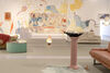 a gallery wall with figures painted on it in. In front of the gallery are sofas and a pedestal 
