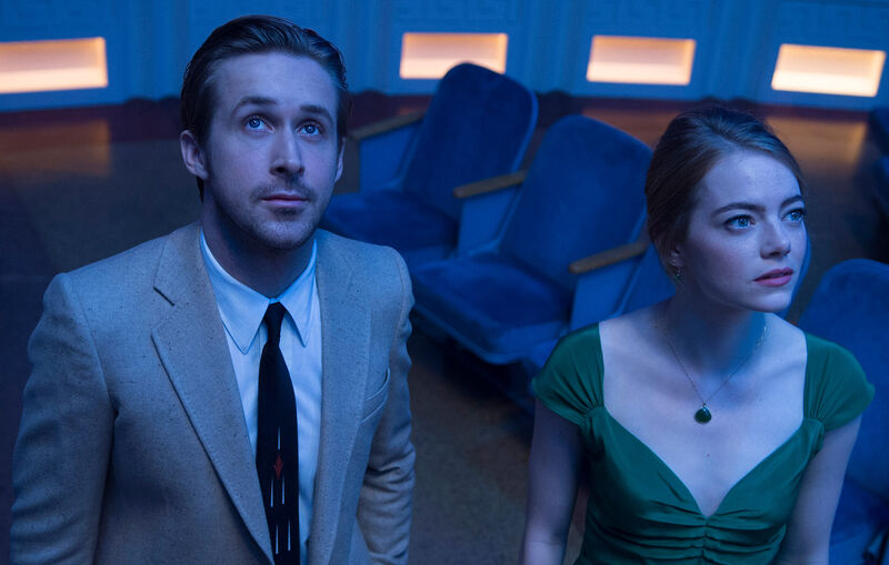 A man and woman look up standing in a planetarium