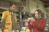 A girl looks in surprise at pregnancy test result while a man in a yellow uniform looks on