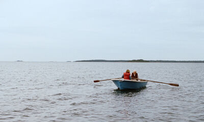 A girl and her grandmother in a rowing boat on the sea