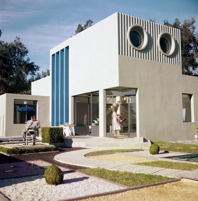 A modernist house with circular windows and a minimalist garden