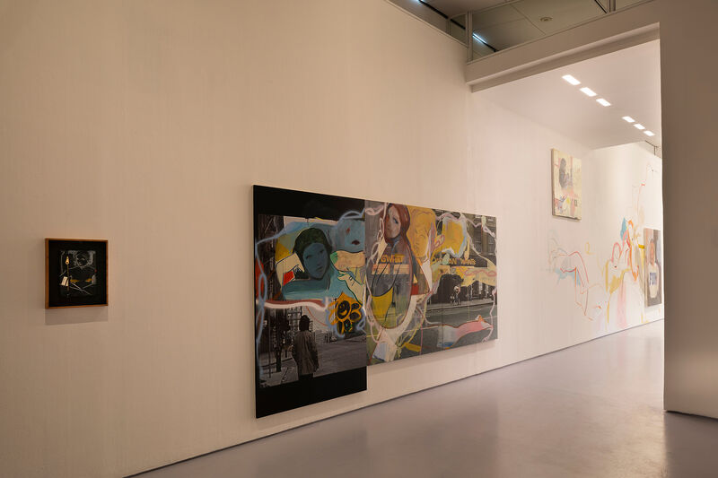 a gallery space with paintings on a wall with female women heads