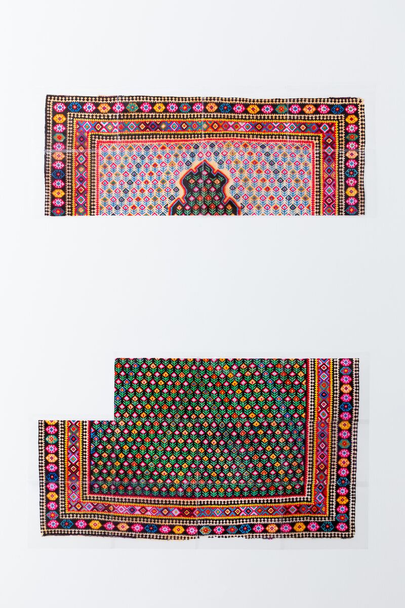 A recreation of a colourful 'family' rug in two parts, with a large gap in the middle. 