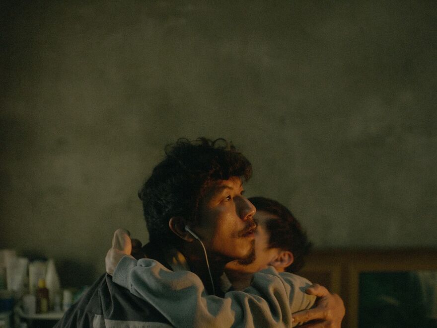 A man with one earphone carries another man.