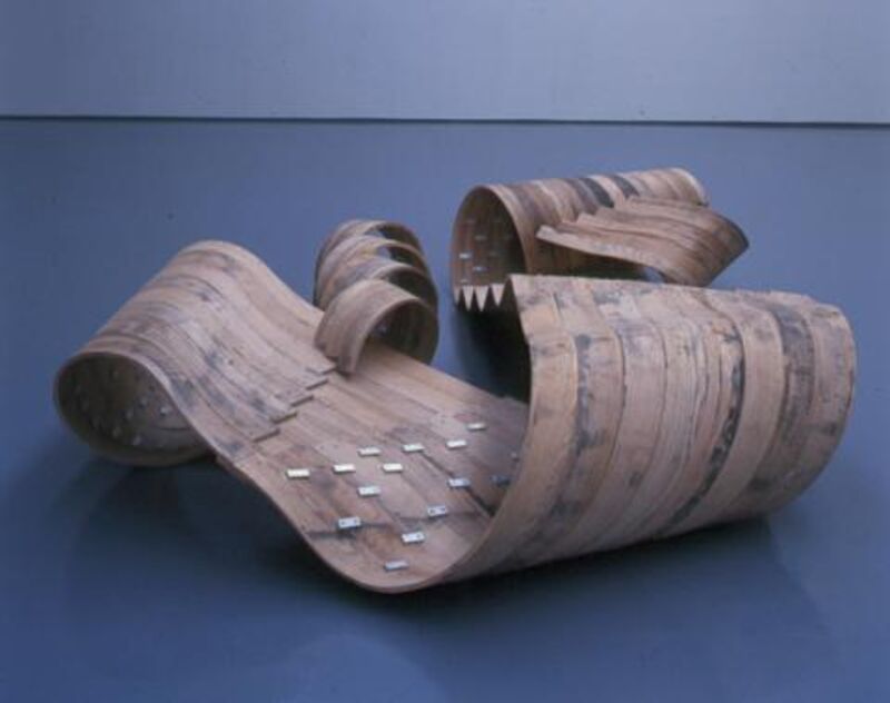 From Richard Deacon's exhibition in DCA Galleries. A sculpture lies on the gallery floors. It is made out of tightly curled wooden ply wood.
