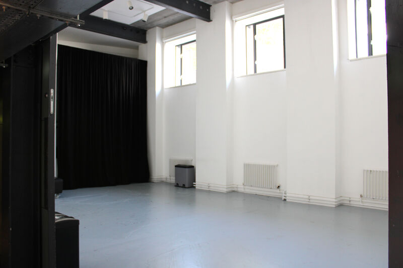 The Centrespace is shown here empty. It has tall white walls, radiators, and grey floors.