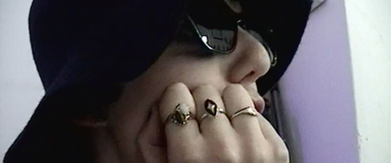 Person wearing a hat, sunglasses and rings