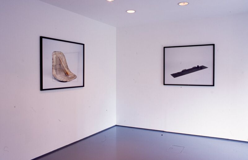 White framed images hang on the wall, which show photographs of abstract sculptures.
