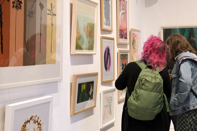 People looking at framed artwork