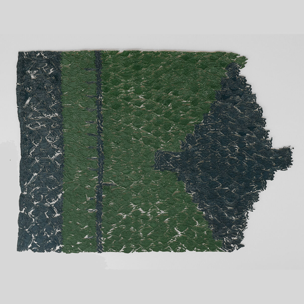 A two-toned fragment of green textile on a grey background
