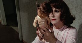 Woman holding a doll hanging from a noose