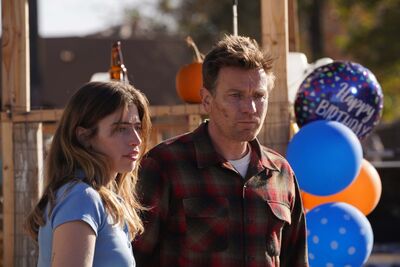 Ewan and Clara McGregor in Bleeding Love, standing in the sunshine surrounded by birthday balloons.