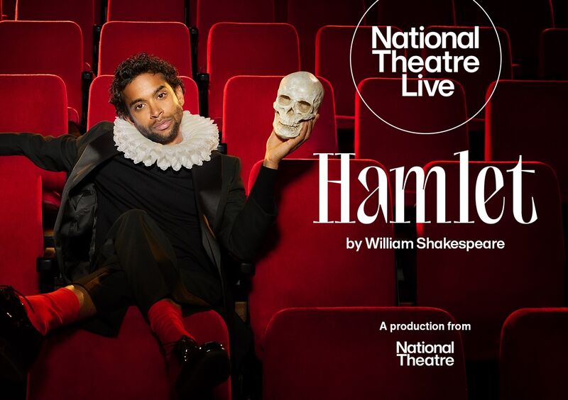A man sits on a red cinema seat, holding a skull and wearing a white collar with ruffles. Text - Hamlet by William Shakespeare, National Theatre Live
