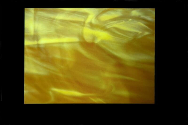 From Cara Tolmie's exhibition. A screen displays a glossy, yellow, shiny image.