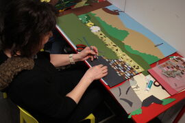 Person creating a backdrop for an animation using collaged paper