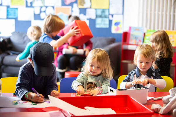 Children sitting at a table in Create Space doing creative activities