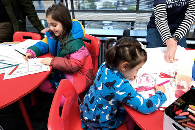 Two young sisters colour in at Discovery Film Festival