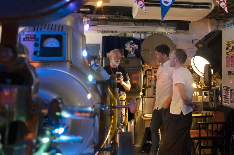 Michael Coull and projectionist Ian Banks giving podcaster Mike Muncer a tour of DCA Projection Booth