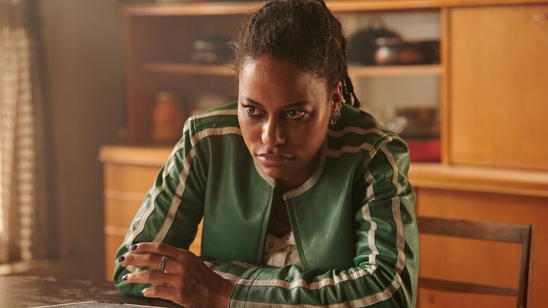 Taylour Paige sitting at a table wearing a green jacket