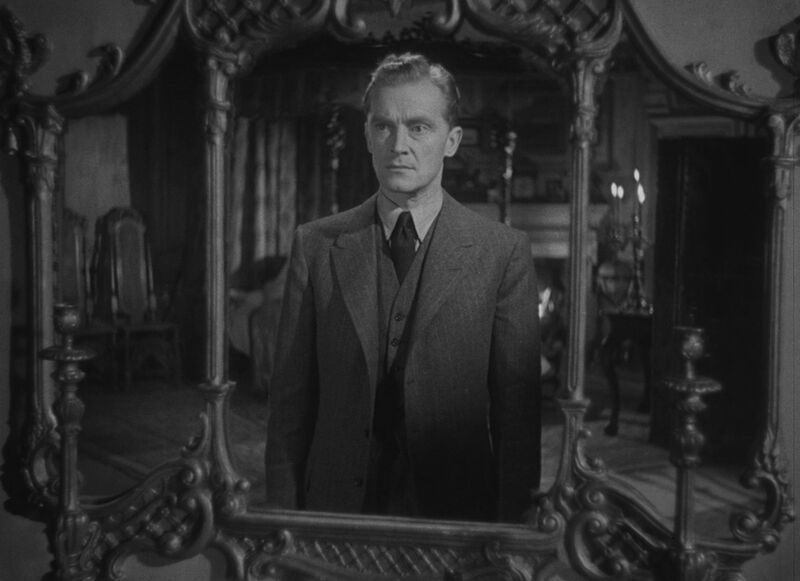 Reflection of a man in an ornate mirror