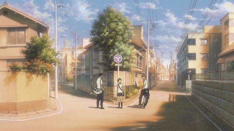 Three school students stand on a quiet street in Japan.
