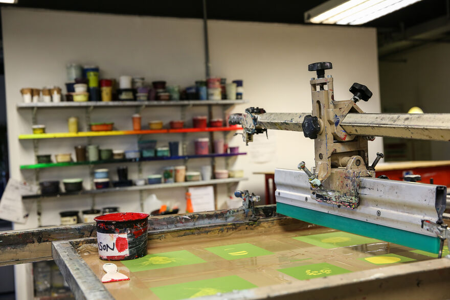 Screen printing table in DCA Print Studio with red ink