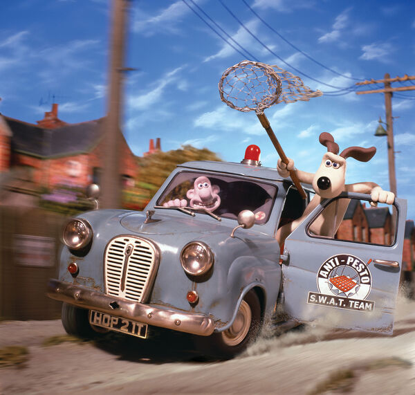 Wallace and Gromit race down the street in their van. Gromit hangs out of the door holding a net