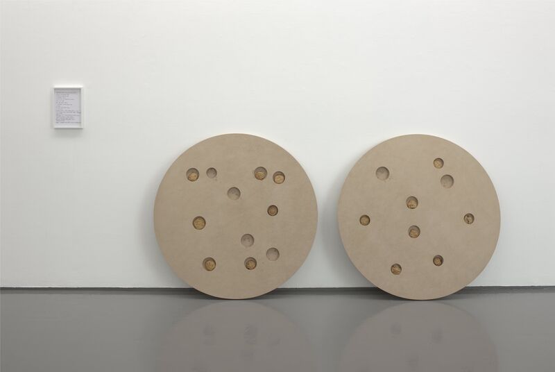 From Infinite Jest, two large circular beige objects rest against the gallery walls.