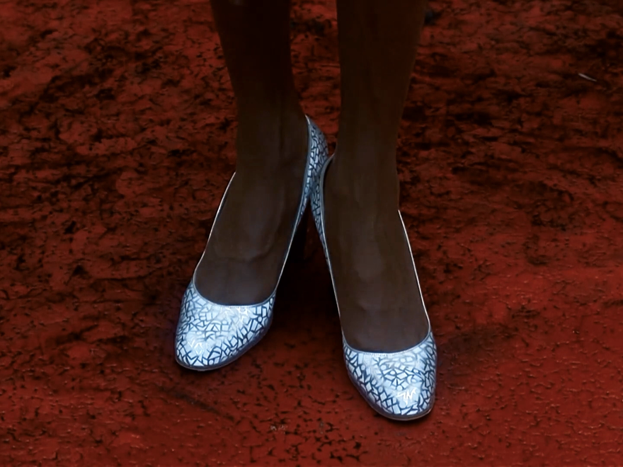 A pair of silver slippers on a ruby red carpet