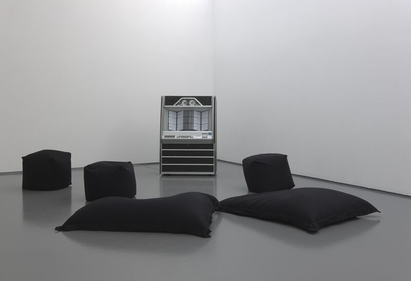 From Ruth Ewan's exhibition. Black cushions and bean bags surround a grey jukebox in DCA Galleries.