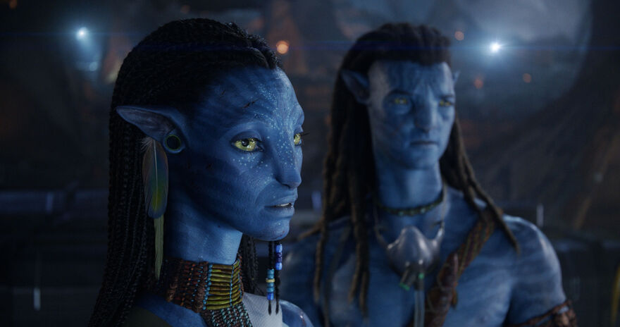 Two blue humanoid aliens wearing jewellery stand next to each other.