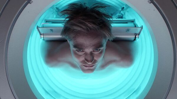 A man lies in a blue tube on a stretcher.
