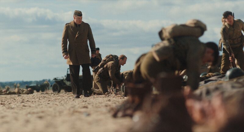 A general stands with his soldiers on a beach