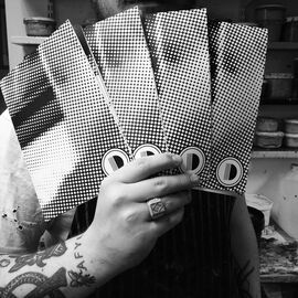 Photo of hand holding Dundee Print Collective printed materials in DCA Print Studio