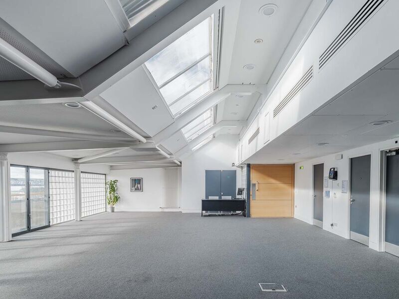 a large empty room with ceiling windows